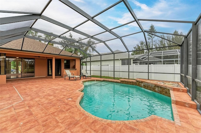 view of swimming pool with pool water feature, glass enclosure, and a patio