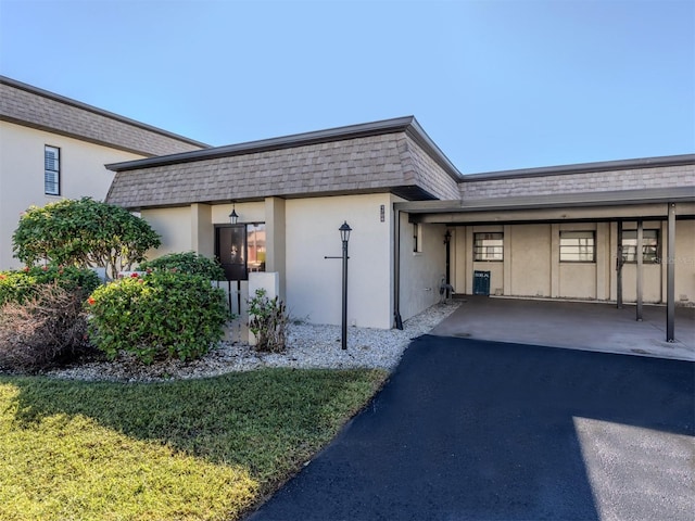1708 Bonitas Cir Unit 1726A, Venice, FL 34293 - view of front of home featuring mansard roof, stucco siding, asphalt driveway, and roof with shingles