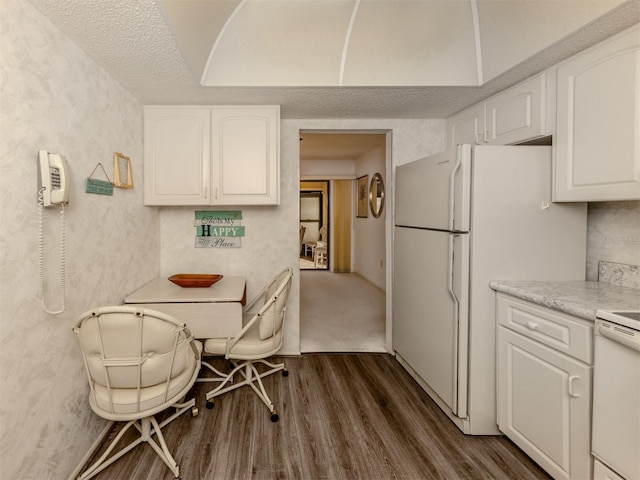 kitchen featuring white appliances, a textured ceiling, dark hardwood / wood-style flooring, and white cabinetry