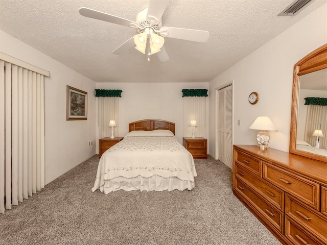 carpeted bedroom with a textured ceiling, a closet, and ceiling fan