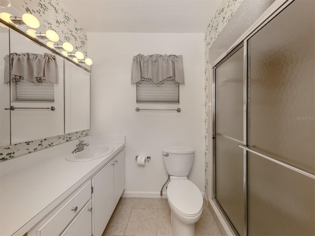 bathroom with tile patterned flooring, vanity, toilet, and an enclosed shower