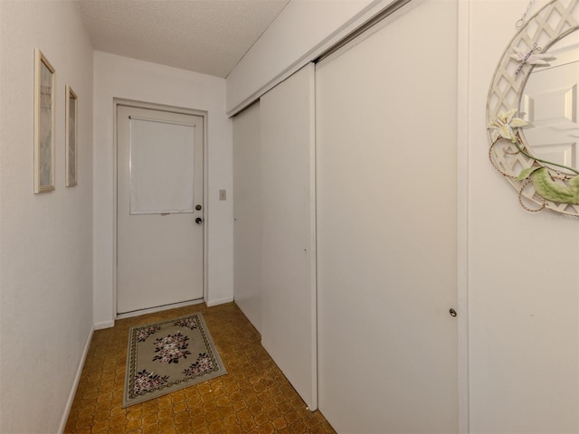 1708 Bonitas Cir Unit 1726A, Venice, FL 34293 - doorway to outside with a textured ceiling and baseboards