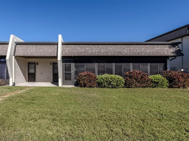 back of property with a lawn and a patio