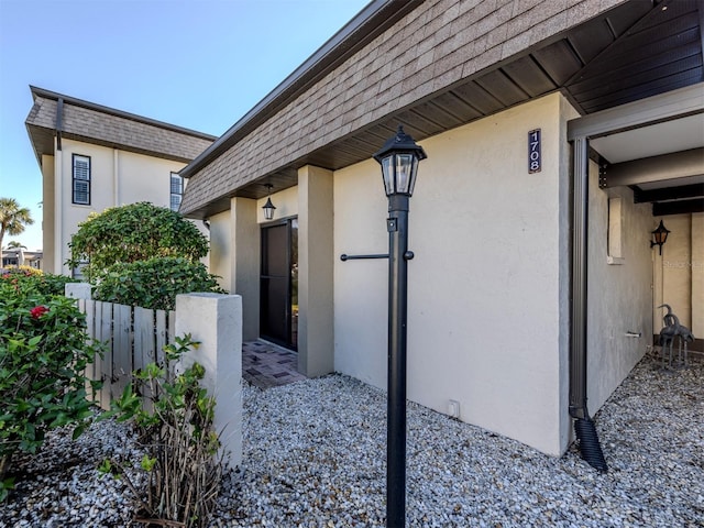 1708 Bonitas Cir Unit 1726A, Venice, FL 34293 - doorway to property featuring stucco siding and roof with shingles