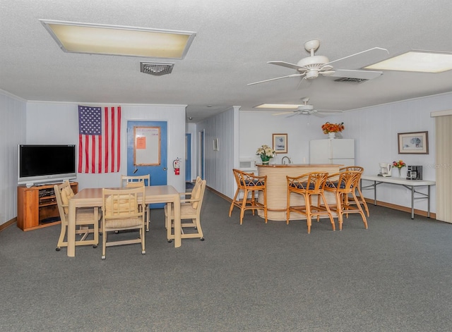 carpeted dining area featuring ceiling fan and a textured ceiling