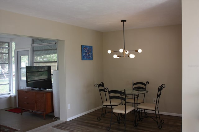 dining area featuring dark hardwood / wood-style flooring and an inviting chandelier