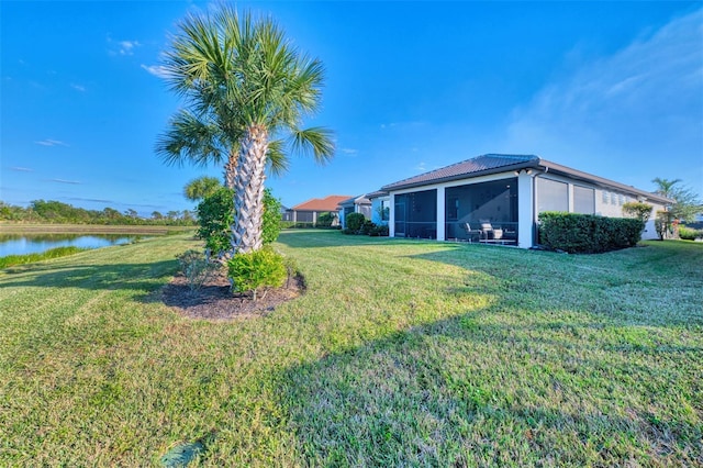 view of yard featuring a water view and a sunroom