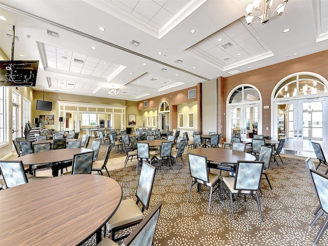 dining space with french doors, coffered ceiling, a high ceiling, an inviting chandelier, and crown molding