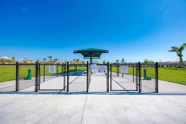 view of gate with a lawn