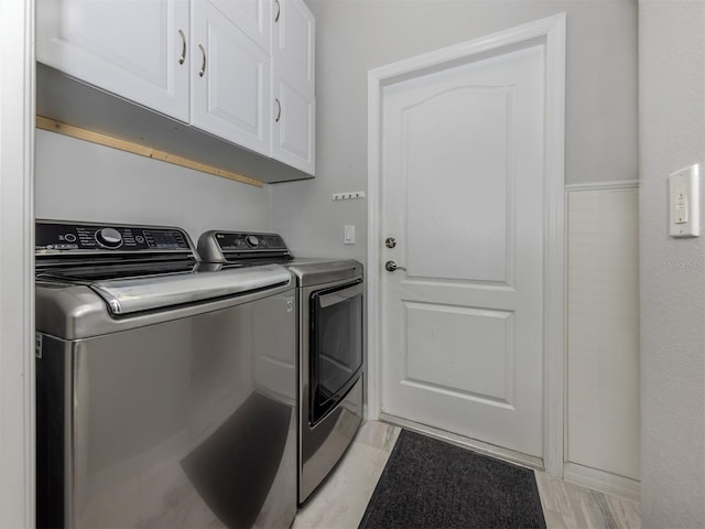 clothes washing area featuring cabinets and washing machine and dryer