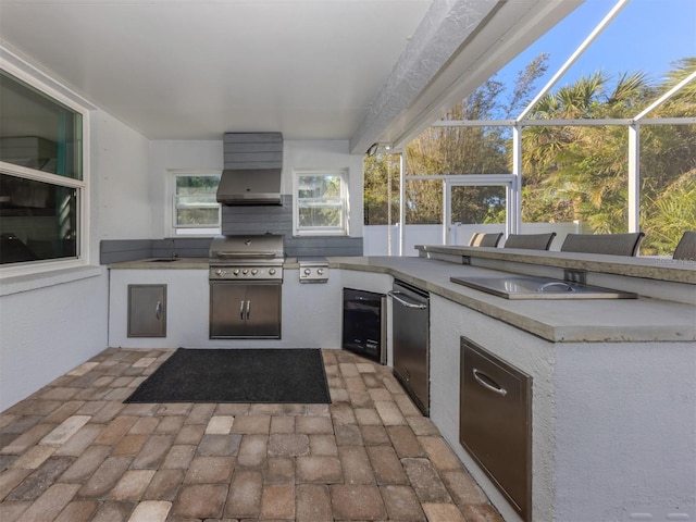 view of patio featuring glass enclosure, a grill, exterior kitchen, and sink