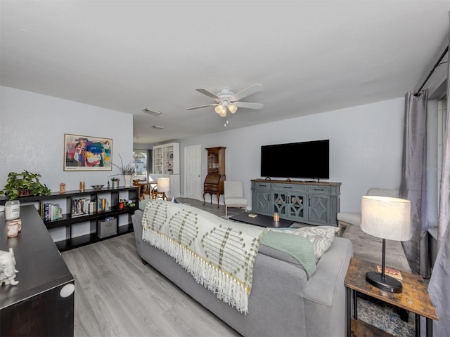 living room with light hardwood / wood-style floors and ceiling fan