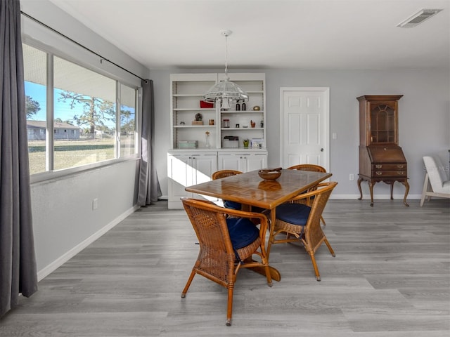 dining area featuring light wood-type flooring and an inviting chandelier