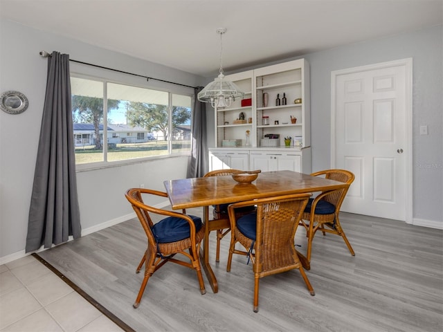 dining space featuring light wood-type flooring and an inviting chandelier