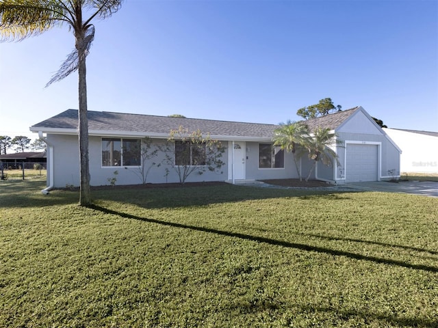 ranch-style home featuring a garage and a front lawn