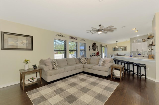 living room featuring dark hardwood / wood-style floors, ceiling fan, and sink