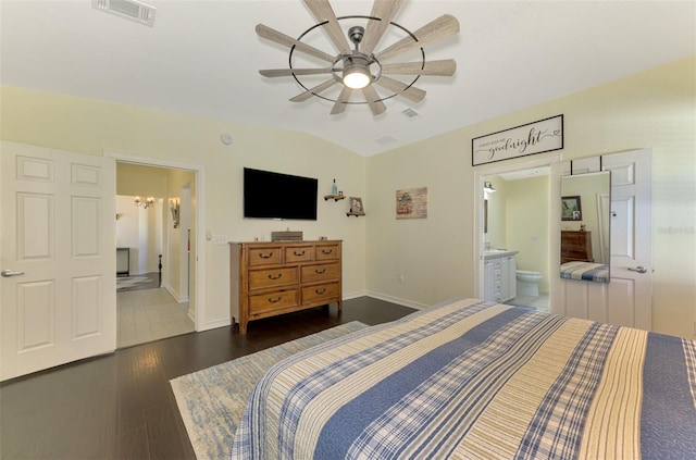 bedroom featuring ceiling fan, dark wood-type flooring, ensuite bathroom, and lofted ceiling