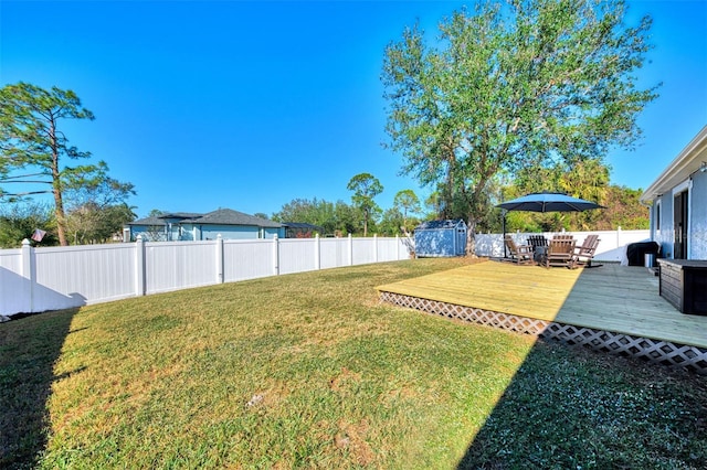 view of yard featuring a storage shed and a wooden deck