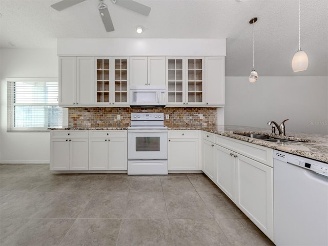 kitchen featuring pendant lighting, white appliances, sink, decorative backsplash, and light stone countertops