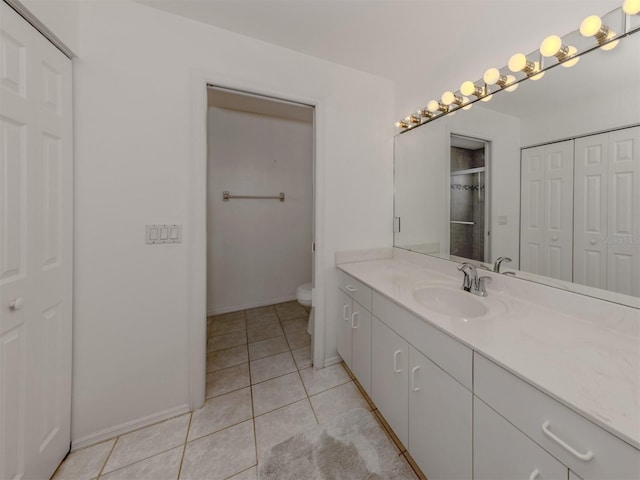 bathroom featuring tile patterned floors, vanity, and toilet