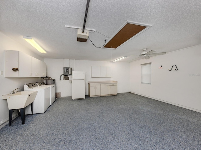 garage featuring ceiling fan, white fridge, a garage door opener, and washing machine and clothes dryer