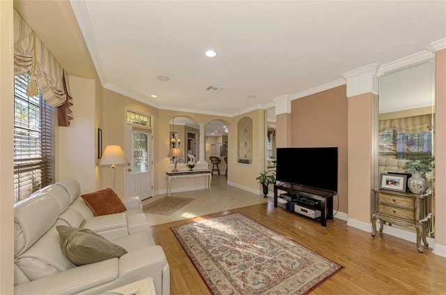 living room with ornate columns, crown molding, and light hardwood / wood-style flooring