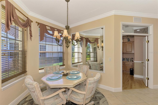 tiled dining area featuring crown molding and a chandelier