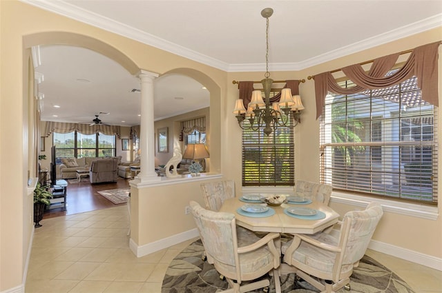 tiled dining space with ceiling fan with notable chandelier, ornate columns, and ornamental molding