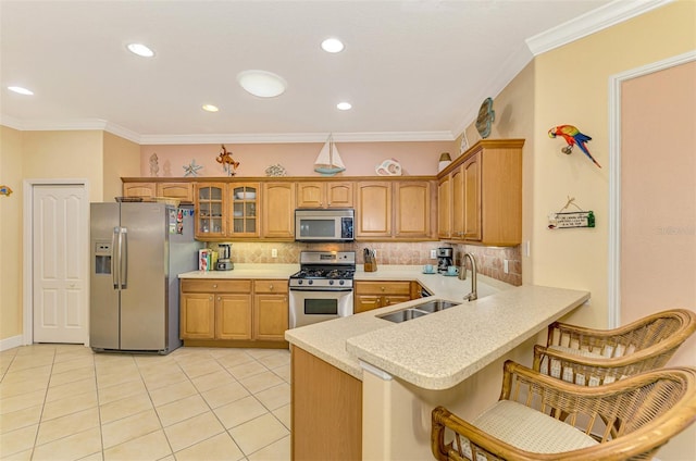 kitchen featuring a kitchen breakfast bar, sink, ornamental molding, kitchen peninsula, and stainless steel appliances