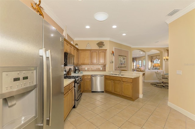 kitchen with crown molding, sink, decorative light fixtures, kitchen peninsula, and stainless steel appliances