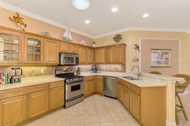 kitchen featuring appliances with stainless steel finishes, crown molding, a kitchen breakfast bar, and sink