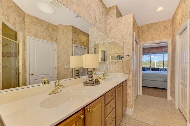4245 Whispering Oaks Dr, North Port, FL 34287 - ensuite bathroom with tile patterned floors, double vanity, a shower stall, wallpapered walls, and baseboards