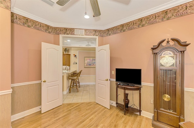 interior space featuring hardwood / wood-style flooring, ceiling fan, and ornamental molding