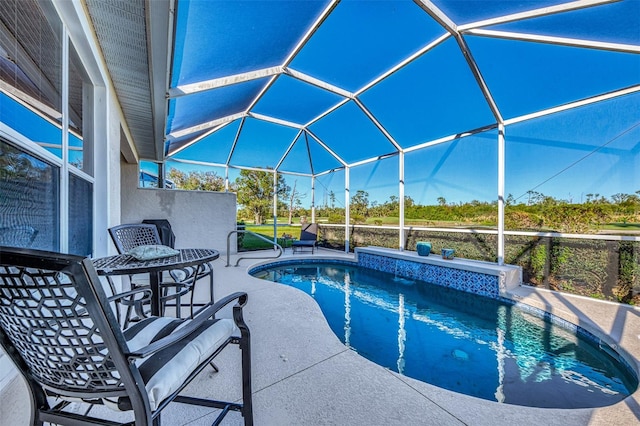 view of pool with glass enclosure and a patio area