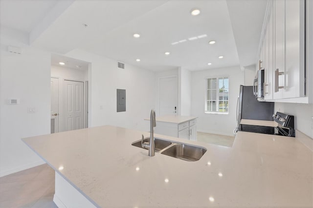 kitchen with a center island, electric panel, black stove, sink, and white cabinetry