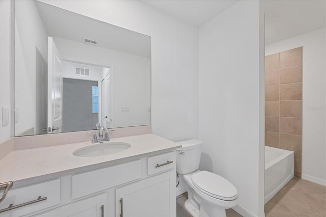 bathroom with toilet, vanity, and tile patterned floors