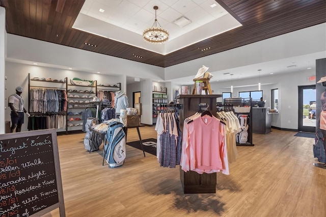 interior space with a tray ceiling, an inviting chandelier, and light hardwood / wood-style floors