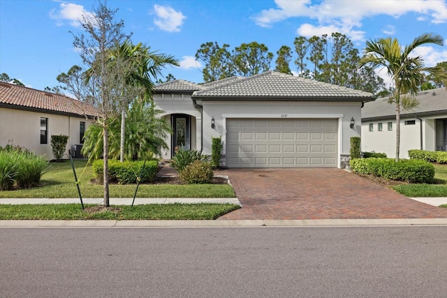 mediterranean / spanish-style home with a garage and a front lawn