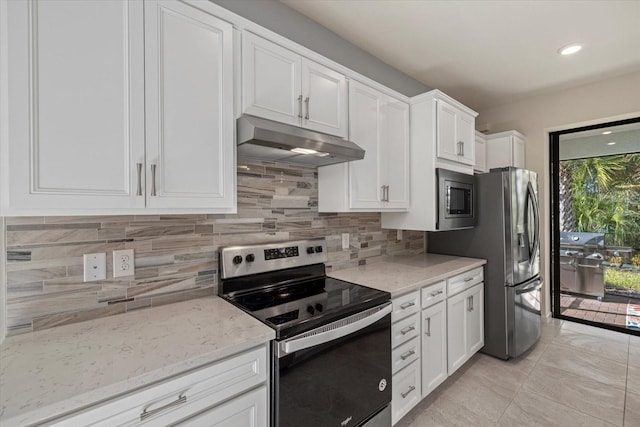 kitchen with tasteful backsplash, light stone counters, white cabinets, and appliances with stainless steel finishes