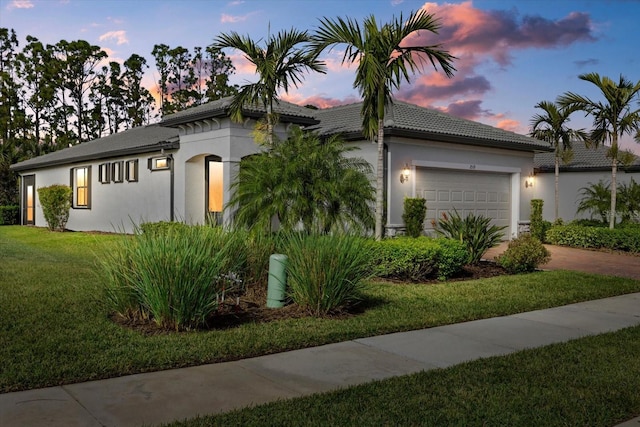 view of front of home featuring a garage and a lawn