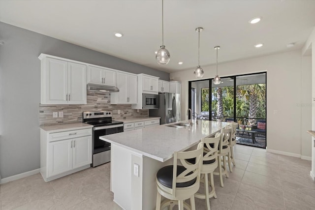 kitchen featuring a kitchen island with sink, light stone countertops, appliances with stainless steel finishes, tasteful backsplash, and white cabinetry