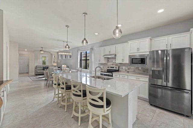 kitchen with white cabinets, ceiling fan, stainless steel appliances, and decorative light fixtures