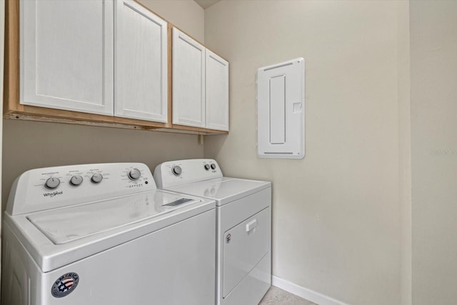 laundry room featuring washing machine and dryer, electric panel, and cabinets