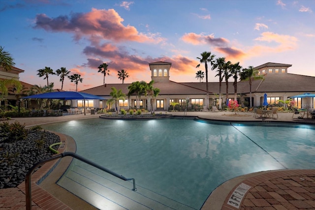 pool at dusk featuring a patio area