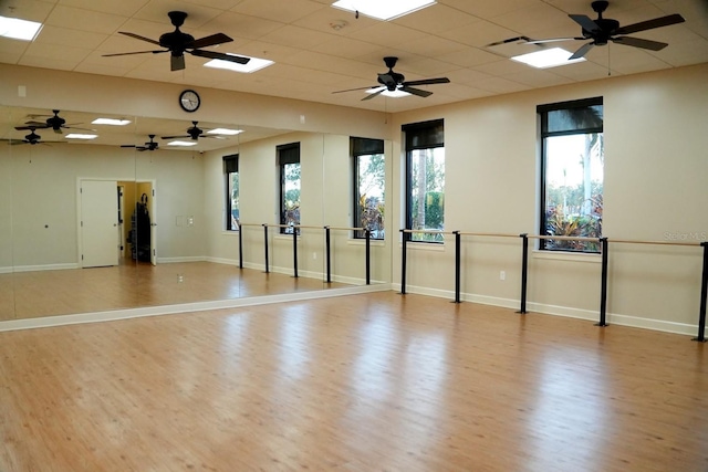 spare room with plenty of natural light, a paneled ceiling, and wood finished floors