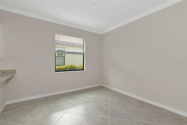 spare room with crown molding, light tile patterned floors, and baseboards