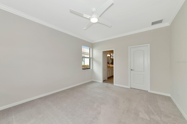 spare room with visible vents, light carpet, a ceiling fan, crown molding, and baseboards