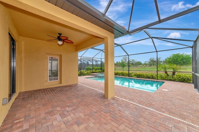 view of pool featuring a patio area, a pool with connected hot tub, a lanai, and a ceiling fan