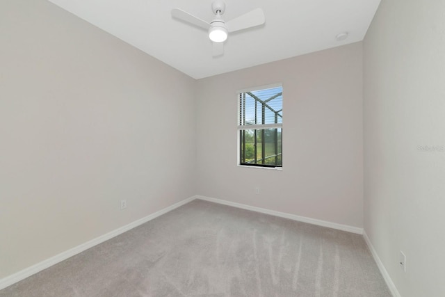 unfurnished room featuring a ceiling fan, light colored carpet, and baseboards