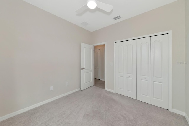 unfurnished bedroom featuring visible vents, light carpet, baseboards, and a closet